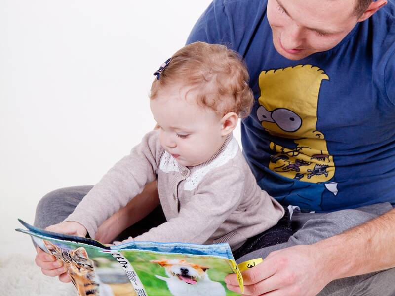 Vater und Kind schauen ein Buch an
